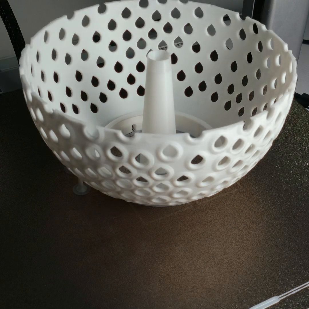 The lamp shell printing as a perforated bowl with teardrop-shaped holes, and a support trunk standing in its middle.