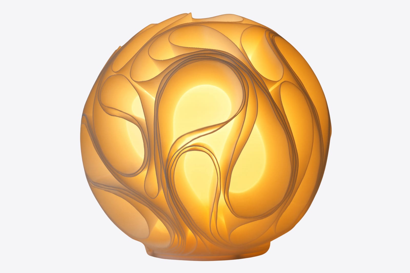 Uma luminária Gravidade impressa em 3D, acesa, com as paredes fluidas brilhando em volta de uma esfera de luz